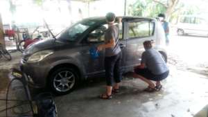 Volunteers helping to wash a car