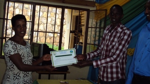 The women receiving a certificate from her teacher