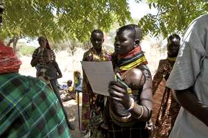 A Turkana mother clutches her health report card