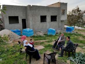 A family chats outside their near-finished home