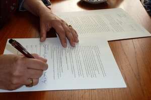 My hand on the Agreement as I sign