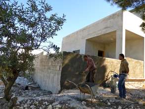 Sadeq and friend plastering the porch he added on