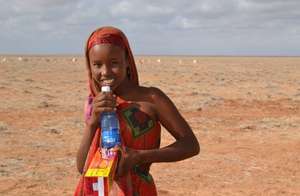 Girl receives food and water from Mercy Corps