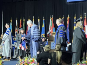 Gloria walks during commencement.