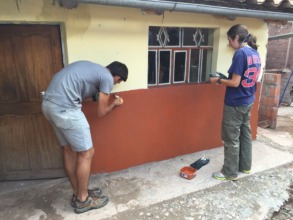 An ARCC student volunteer paints Epi's house