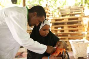 Abdi checks the health of a newborn