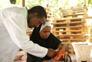 Abdi checks the health of a newborn