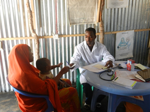 The doctor handing Ikhlaas' mother a prescription