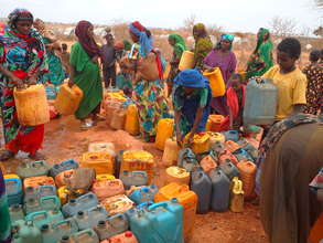 Refugees wait to clean jerry cans.