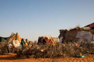 Nadifu's sons stand behind makeshift camp fencing