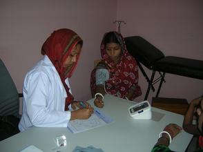 Dr. Dilrupa Akther checking a patient.