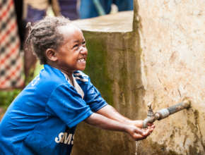 A young girl washes her hands with the clean water