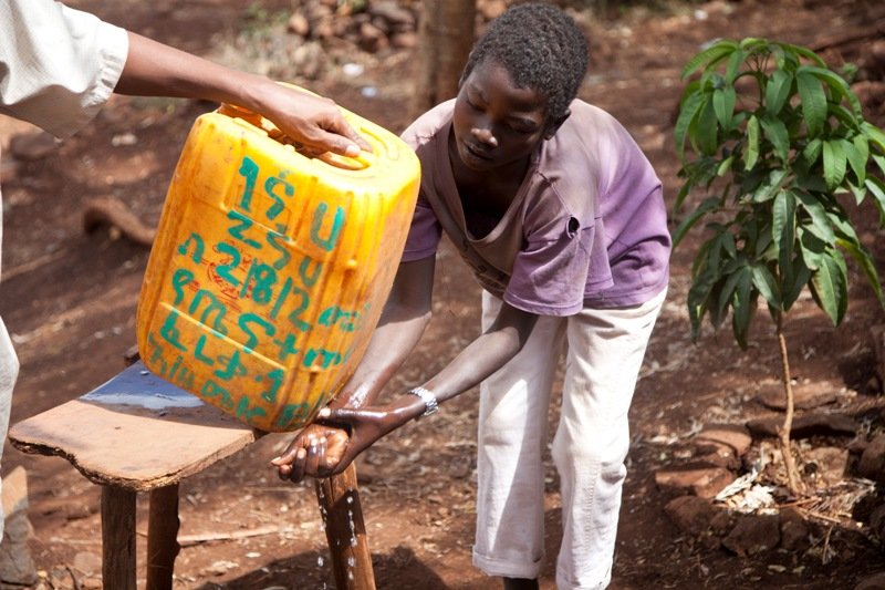A boy washes his hands with clean water