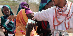 Deeq handing out milk to Somali refugees