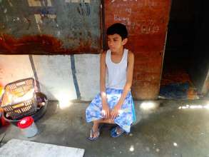 Paul outside his family's humble one-room shack