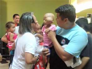 Pidot interacting with a baby with tumor