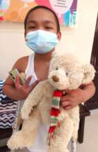 A boy in hospital holds his stuffed animal friend