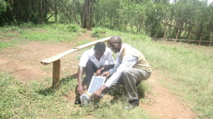 Henry and a student installing solar lights