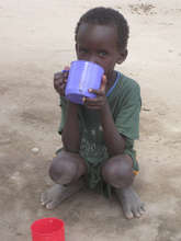 This boy is happy to have a cup to drink water.