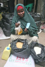 A woman receives rice, beans, oil, sugar and salt