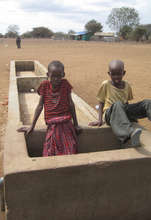 Kids play in a dry trough.