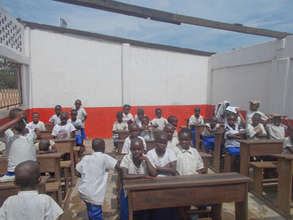 Roofless students endure extreme heat in class.