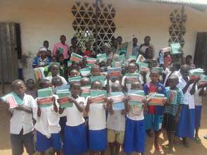 Students hold up their new math kits and notebooks