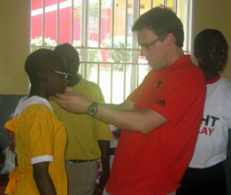 Johann helps Annet Nakazibwe wear her new glasses