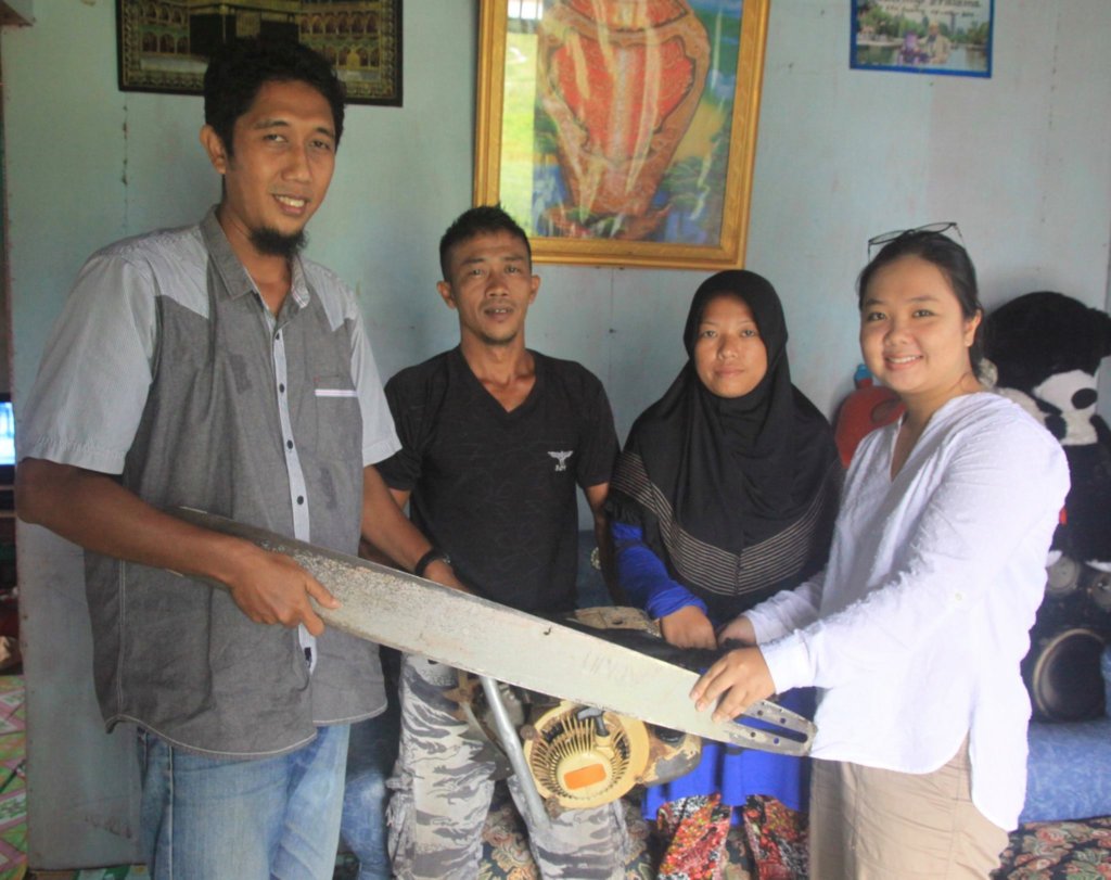 Herwandi, his wife, and Monica with his chainsaw