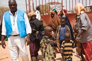 UNHCR staff brings a family into reception center