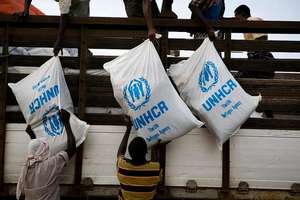 Aid items are unloaded from a truck in Al Adala.