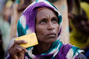 A Somali woman shows her UNHCR card to receive aid
