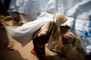 A woman collects her UNHCR aid package in Somalia.