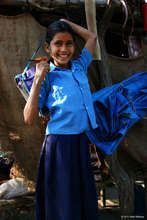 A happy girl packs her schoolbag