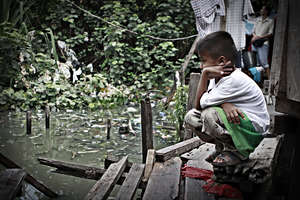 Boy next to slum house