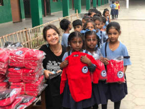 Ineke Zondag giving out winter clothes to children