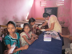 Girls give blood samples at Health Camp
