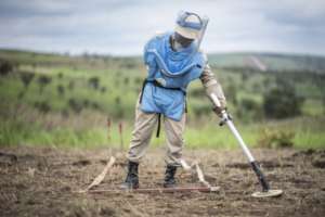 A deminer searches the field in Angola