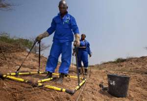 Deminers using a large loop detector at Malhazine