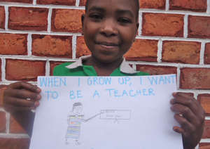 Judith holding her drawing of herself as a teacher