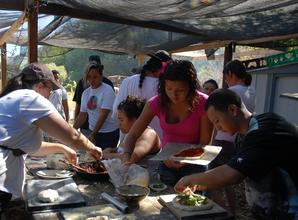 Youth making pizza from ingredients they harvested
