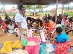 Mothers learn to locally mix nutritious porridge.