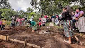AO mentor teaching girls how to plant crops safely