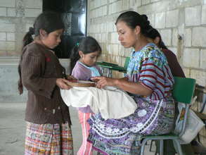 Intern teaching girls sewing skills
