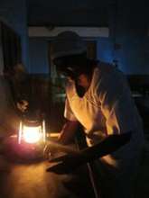 Midwife using kerosene lantern for delivery