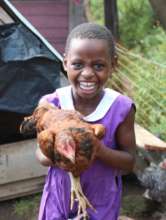 Nyaka student playing with chicken on Desire farm