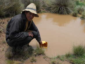 A villager collects water from the current source.