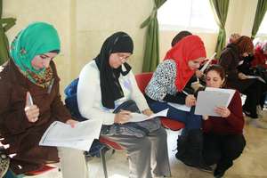 Suhad helps a participant with her self-evaluation