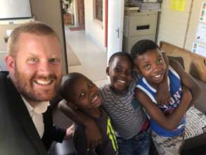 Boys united smiling with project leader Harrison