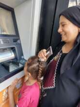 Mona withdrawing cash from the ATM